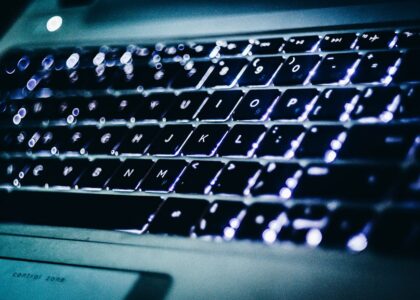 A modern digital workspace with a glowing laptop and financial graphs.