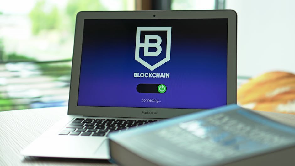 A digital workspace with a laptop and abstract blockchain representations.