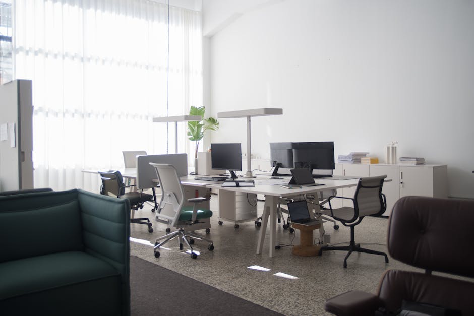 A collaborative office space with computer workstations and natural lighting.