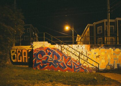 Urban landscape with graffiti art and soft streetlights at dusk.