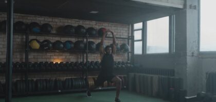 A vibrant gym filled with fitness equipment and blurred exercising silhouettes.