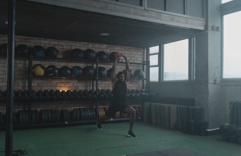 A vibrant gym filled with fitness equipment and blurred exercising silhouettes.
