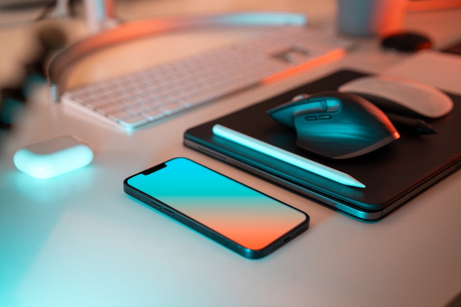 A clean desk with a MacBook and pastel-colored tech accessories.