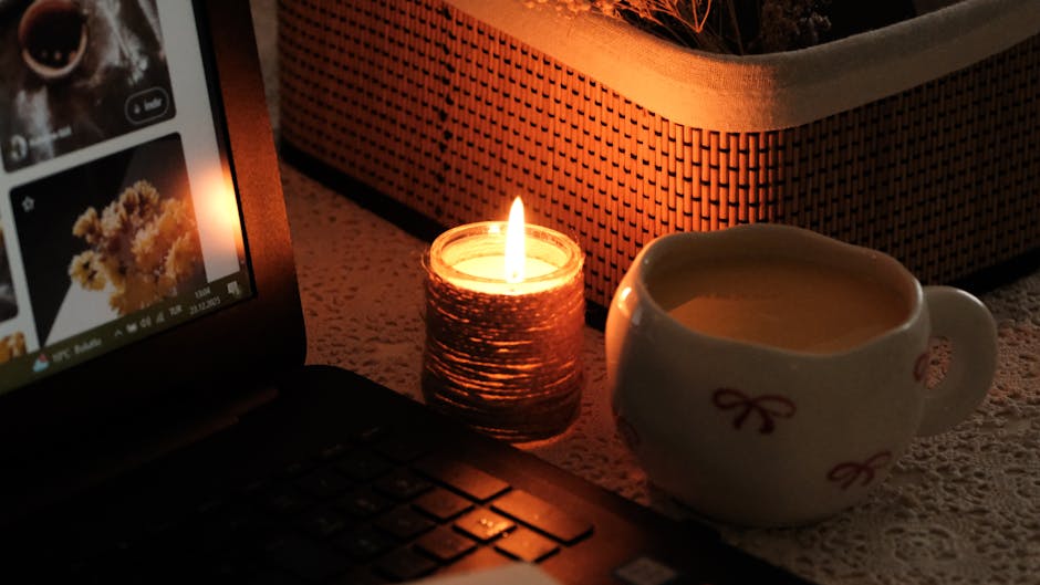 Cozy room with warm lighting, chair, table, and glowing laptop screen.
