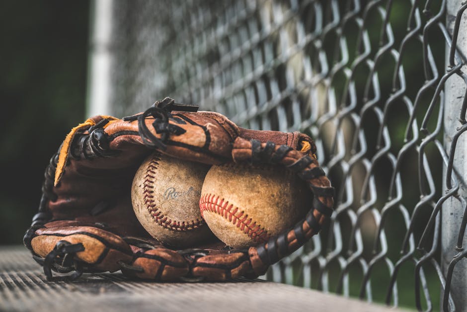 A baseball field at sunset with a glove and ball in the foreground.