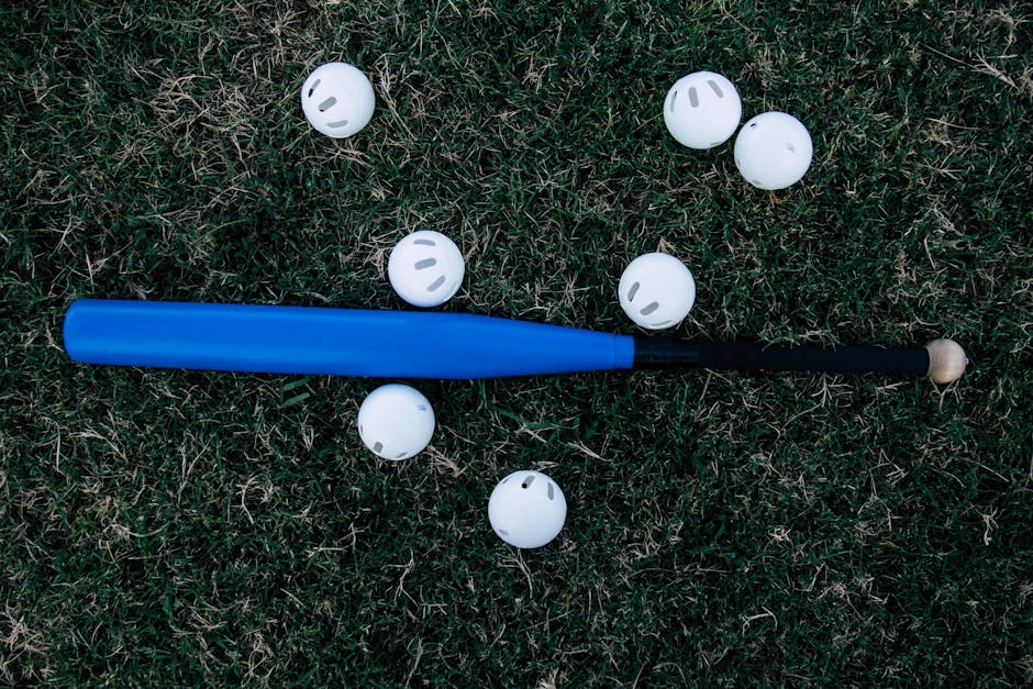 A baseball field with a bat and ball under a blue sky.