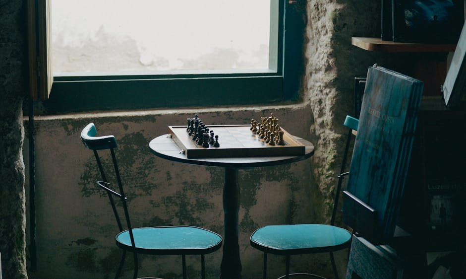A game room with a table, chairs, and scattered game pieces.