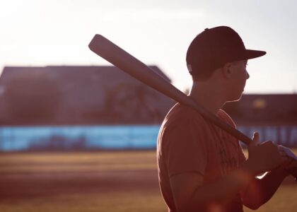 A baseball field at sunset with a bat on home plate.