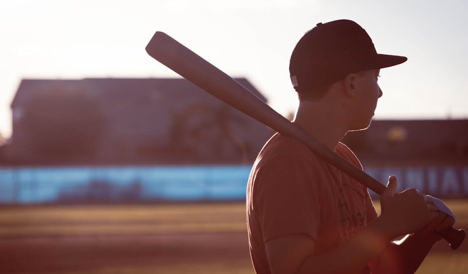 A baseball field at sunset with a bat on home plate.
