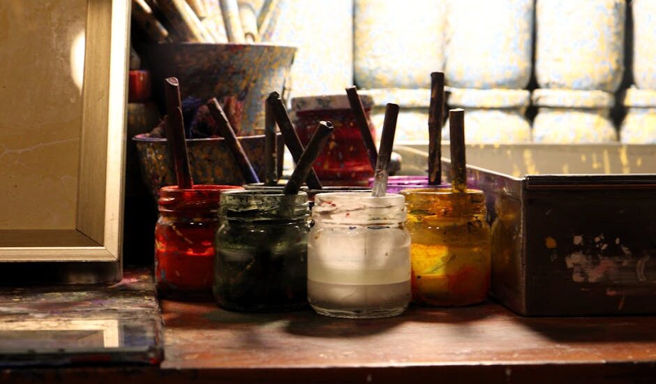 A colorful digital art studio with paint splatters and brushes.