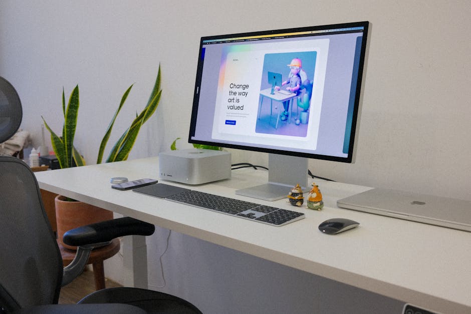 A sleek workspace with a computer and vibrant digital artwork on the screen.