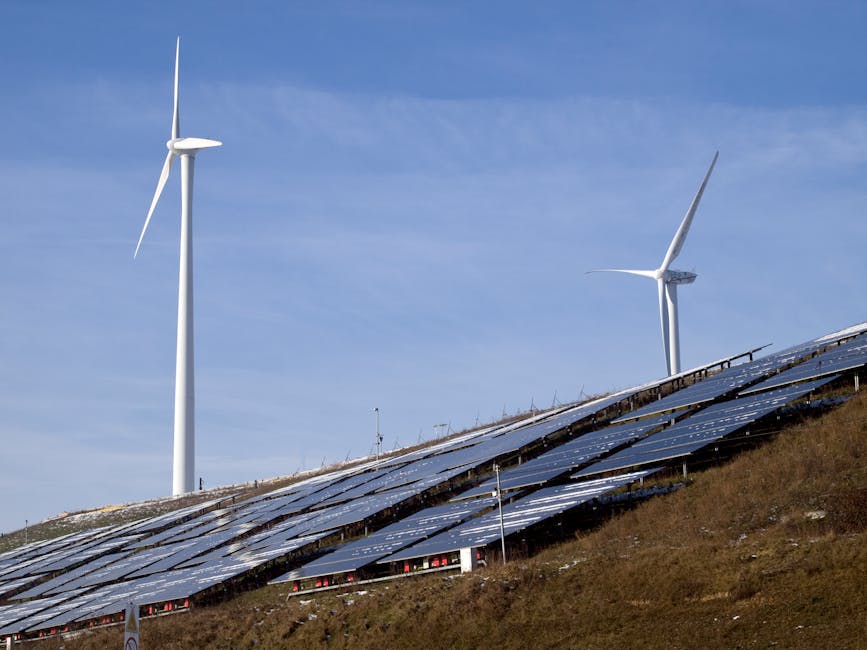 Landscape with solar panels and wind turbines on a green hillside