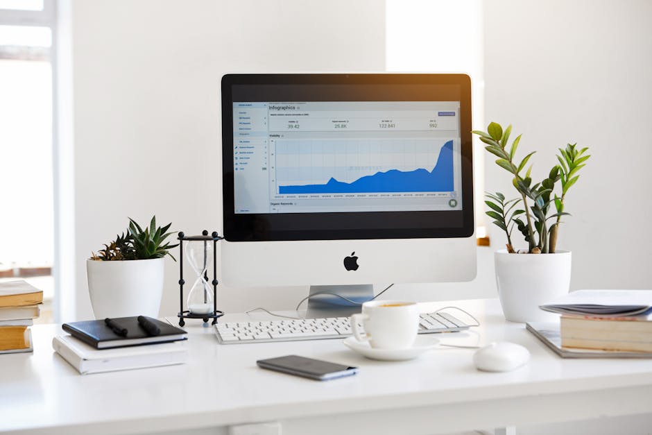 A modern workspace with a computer and analytics graphs displayed