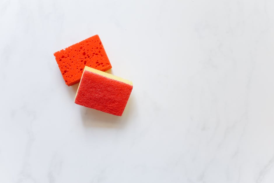 A modern kitchen countertop with sponges and cleaning tools arranged neatly.