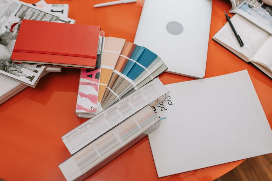 A modern workspace with a laptop and colorful design tools on a desk.