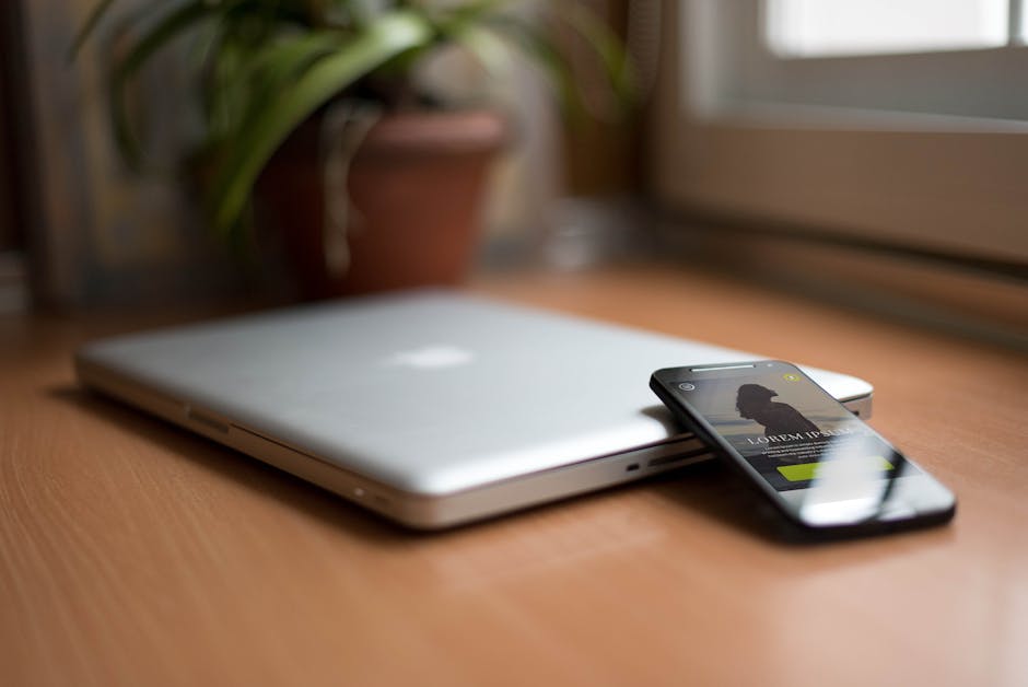 A laptop on a wooden desk with abstract tech patterns in the background.