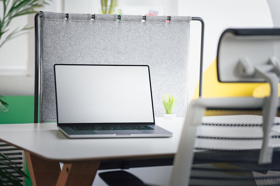 A modern workspace with a laptop and colorful design materials.