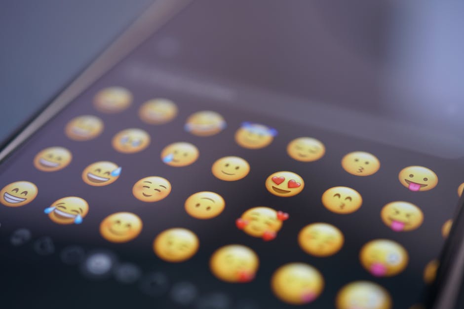 A smartphone on a table with a colorful chat interface and emojis