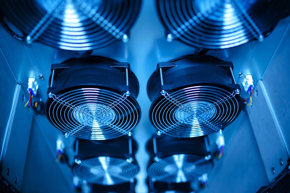 A setup of ASIC miners with glowing lights and cooling equipment in a dark room.