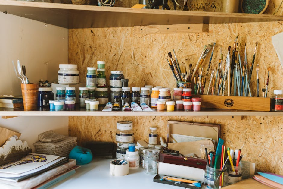 An artist's workspace with paints, brushes, and canvases.