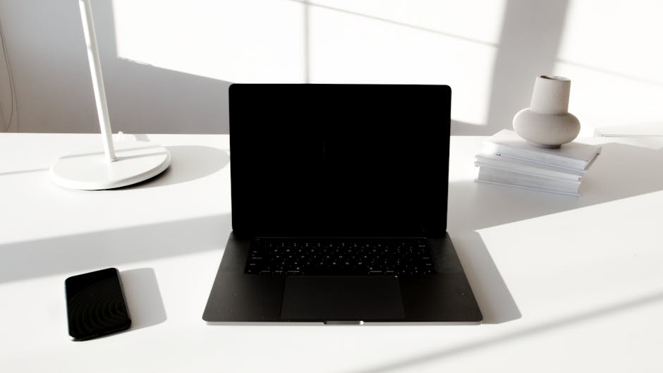 A modern workspace with a laptop and design tools on a desk.