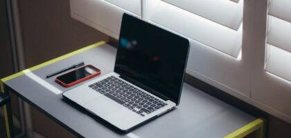 A modern office setup with a laptop and financial documents on a desk.