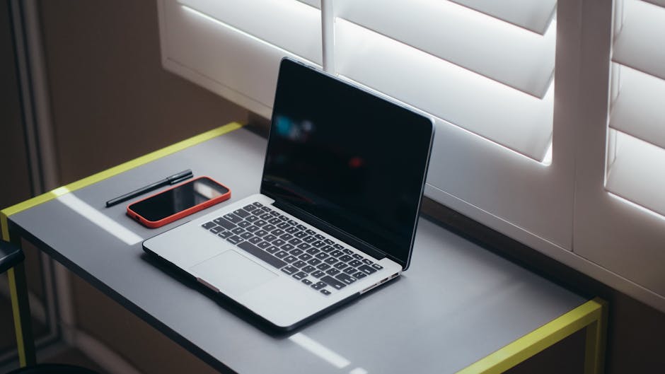 A modern office setup with a laptop and financial documents on a desk.