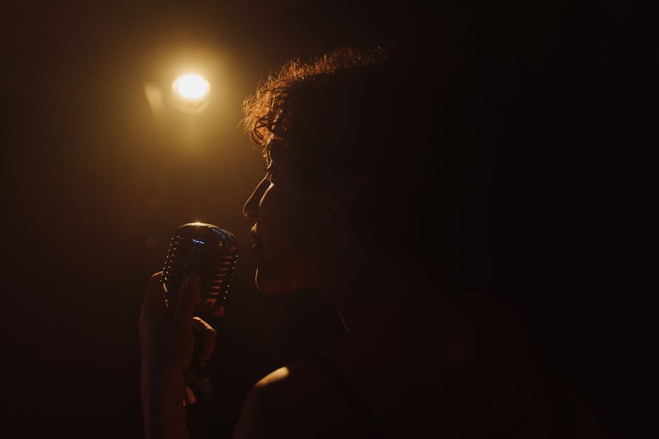 A vintage microphone on a dimly lit stage with warm lights.