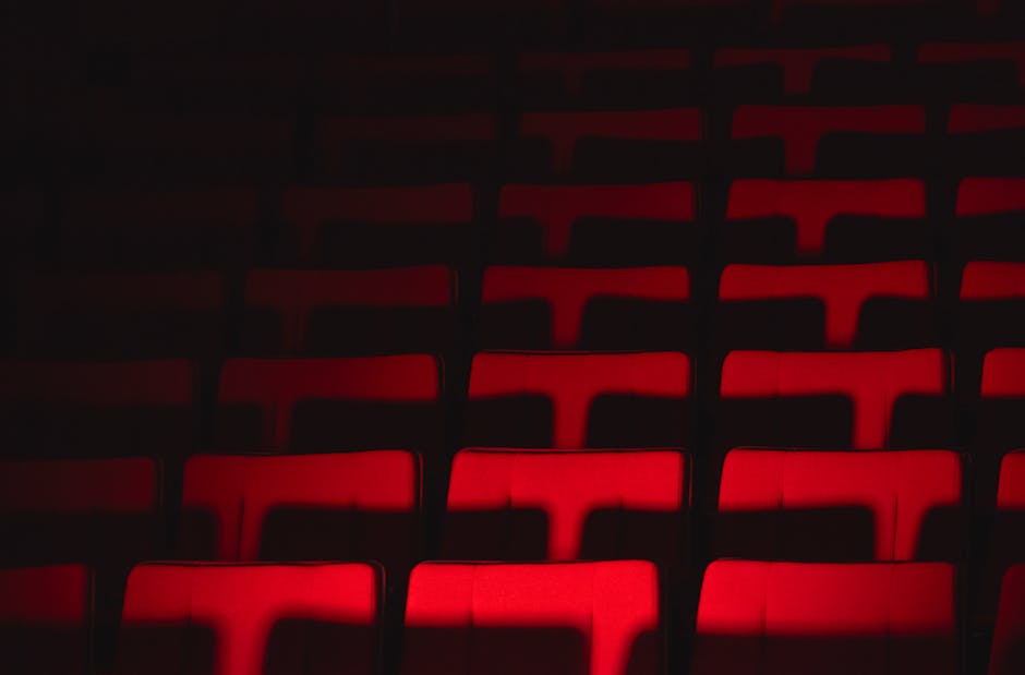 A theater stage with colorful lights and empty seats.