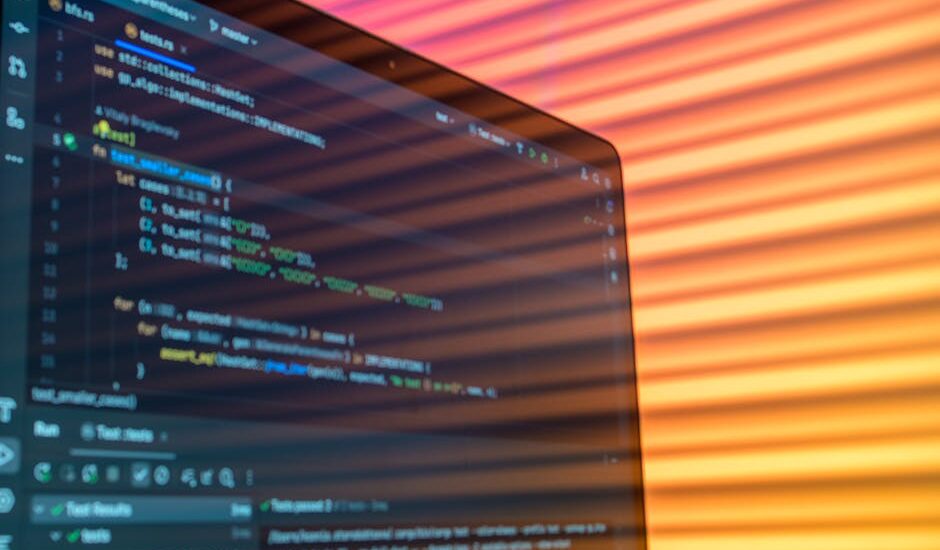 A colorful workspace with coding books and a laptop under natural light.